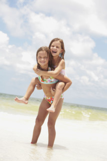 Girl carrying sister in ocean. Date : 2008
