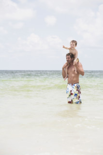 Father carrying son on shoulders in ocean. Date : 2008