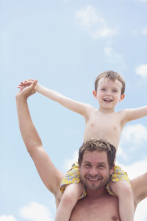 Father carrying son on shoulders. Date : 2008