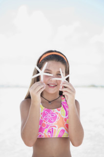 Girl on beach holding delicate starfish. Date : 2008