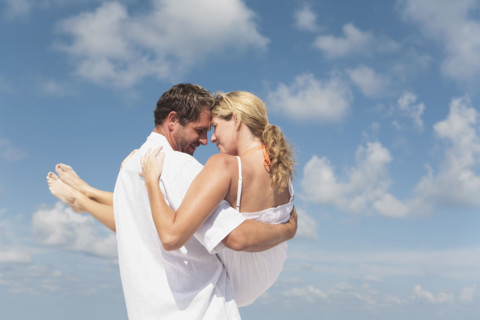 Man carrying girlfriend on beach. Date : 2008