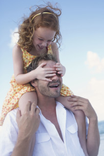Father carrying daughter on shoulders. Date : 2008
