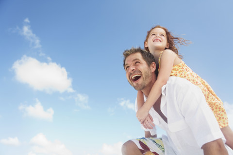 Father carrying daughter on shoulders. Date : 2008