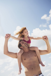 Father carrying daughter in shoulders. Date : 2008