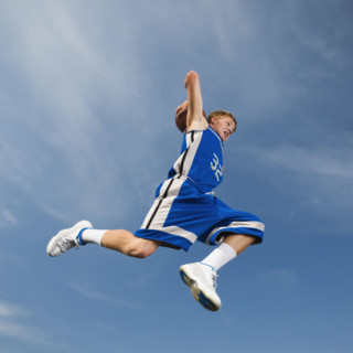 Teenage basketball player in mid-air throwing basketball. Date : 2008