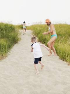 Mother running on beach with daughter and son. Date : 2008
