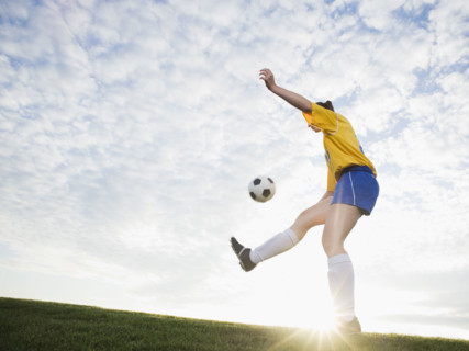 Teenage girl kicking soccer ball. Date : 2008