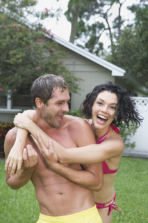 Couple in bathing suits hugging in backyard. Date : 2008