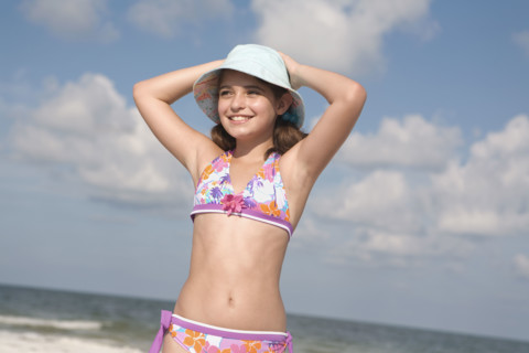 Portrait of girl on beach with hands behind head. Date : 2008