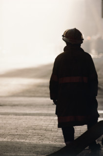 Silhouette of fireman looking at smoke in distance. Date : 2008