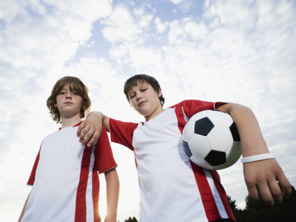 Portrait of boys in soccer uniforms holding ball. Date: 2008