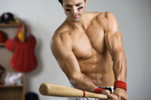 Baseball player with bare chest warming up with bat. Date: 2008