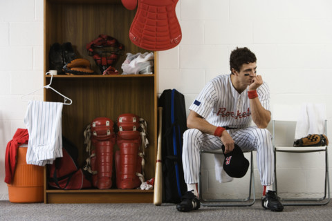 Baseball player sitting in locker room looking pensive. Date : 2008