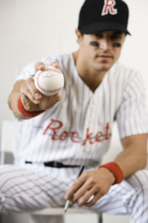 Portrait of baseball player holding autographed baseball. Date : 2008