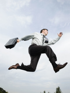 Businessman with briefcase jumping in mid-air. Date: 2008