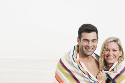 Portrait of couple wrapped in towel at beach. Date : 2008