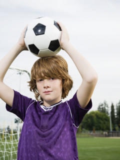 Portrait of boy holding soccer ball on head. Date : 2008