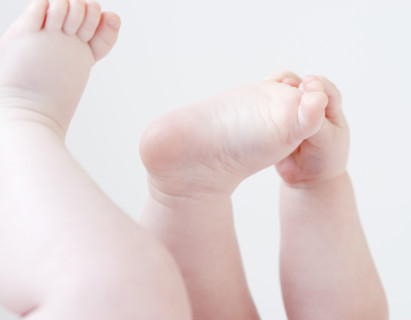 Close up of baby grabbing feet. Date : 2008