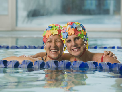 Women in swim caps hugging in swimming pool. Date : 2008