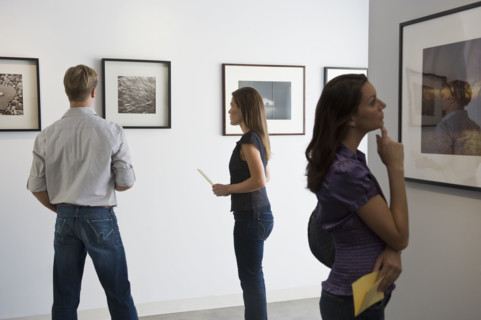 People looking at pictures in art gallery.