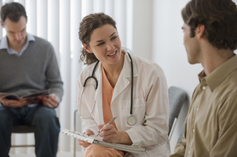 Female doctor in waiting room with male patient.