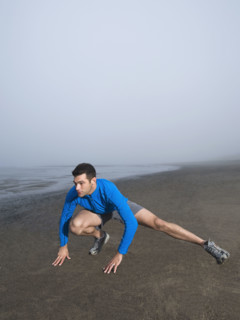 Man stretching on foggy beach. Date : 2008
