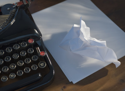 Crumpled paper next to antique typewriter.