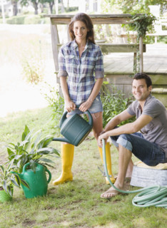 Couple watering plants in backyard. Date : 2008