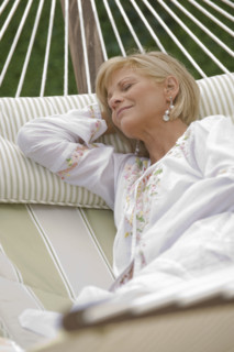 Woman napping on hammock.