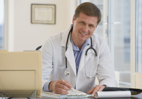 Male doctor posing at desk.