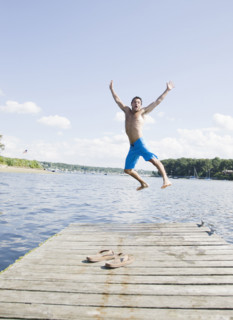 Portrait of man jumping off dock into lake. Date : 2008