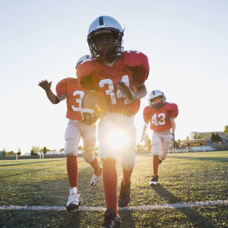 Football players running on field. Date: 2008