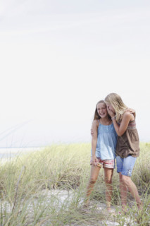 Girls whispering in beach grass. Date : 2008
