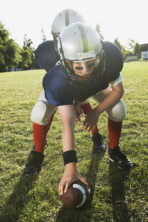 Football center preparing to snap football. Date: 2008