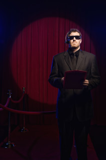 Bouncer with guest list standing near velvet rope. Date: 2008