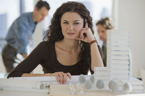 Portrait of architect with blueprints and building model.
