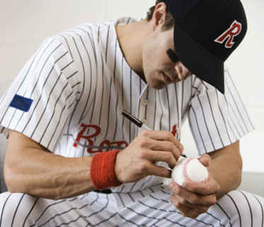 Close up of baseball player autographing baseball. Date : 2008
