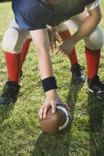 Football center preparing to snap football. Date: 2008