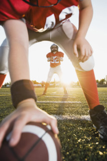 Football center preparing to snap football to quarterback. Date : 2008
