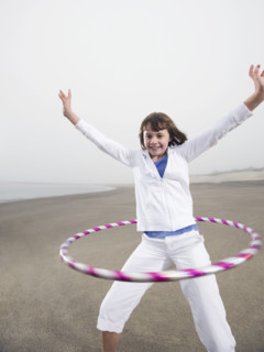 Portrait of girl with hula hoop on beach. Date : 2008