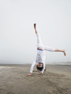 Portrait of girl doing handstand on beach. Date : 2008