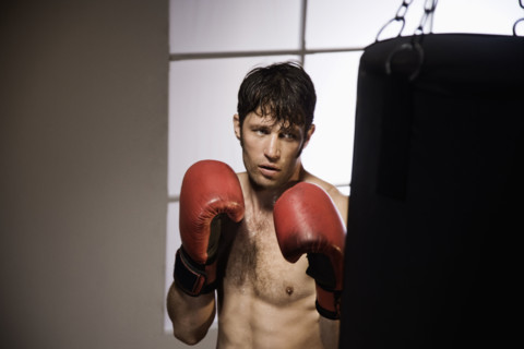 Boxer training with punching bag. Date : 2008