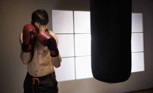 Boxer training with punching bag. Date : 2008