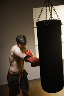 Boxer training with punching bag. Date : 2008