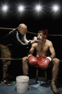 Coach wiping boxer with sponge in corner of boxing ring. Date : 2008