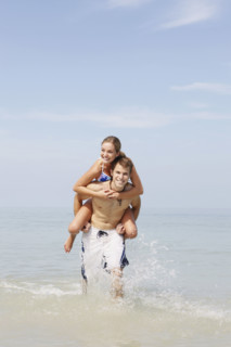Couple splashing in ocean surf. Date : 2008