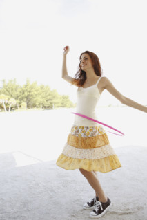 Woman on beach with hula hoop. Date : 2008