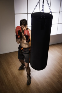 Boxer training with punching bag. Date : 2008