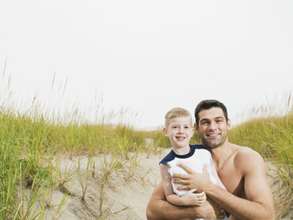 Portrait of father and son hugging on beach. Date : 2008