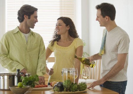 Friends preparing meal in kitchen.